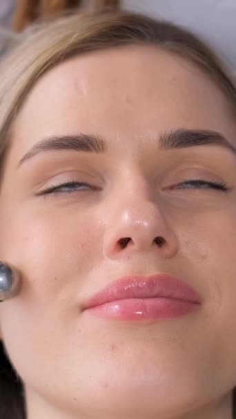 Kosmetolog Dává Omlazující Masáž Obličeje Uvolněné Ženě Pomocí Elektrického Masážního — Stock video