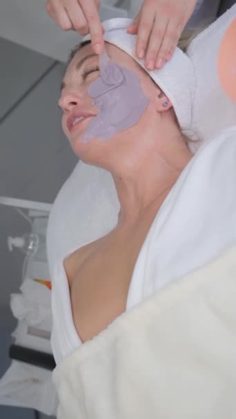 Tilfredse Glade Kvinde Påføring Fugtgivende Maske Kosmetolog Elegant Kvinde Skønhedssalon – Stock-video