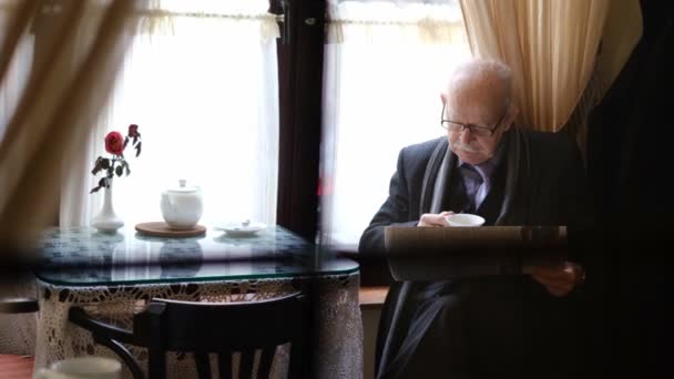Pensionato Anziano Occhiali Leggere Quotidiano Seduto Una Caffetteria Bere Caffè — Video Stock