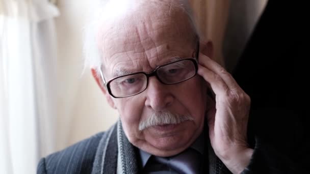Пожилой Человек Сидит Кресле Головной Болью Беспокойство Морщит Лоб Стресс — стоковое видео