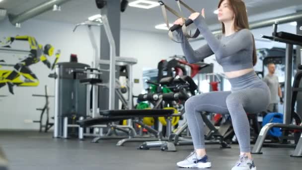 健身锻炼漂亮的女孩在体育馆里做蹲式运动 交叉适应训练 垂直录像 — 图库视频影像