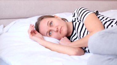 Depresyondaki üzgün genç kadın hasta ve depresyonda yatıyor. Evde hasta bir gün..