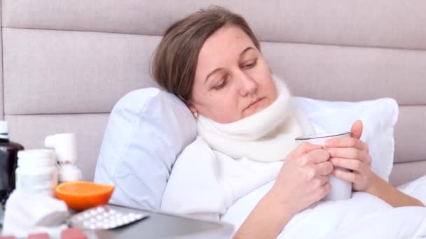 독감이있는 소녀는 침대에 앉아서 집에서 마신다 인플루엔자 그녀는 감기를 잡았습니다 — 비디오