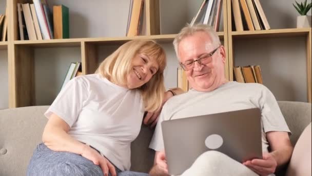 Счастливая Пара Средних Лет Чатится Дома Используя Ноутбук Веселая Пара — стоковое видео