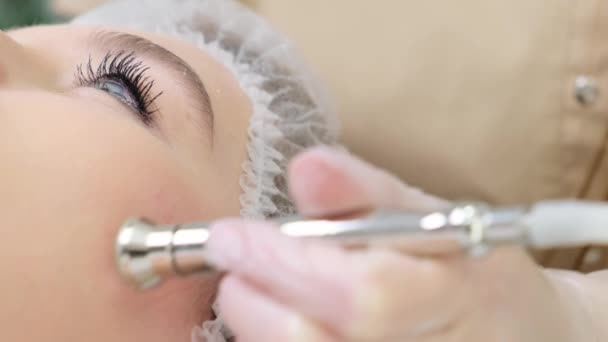 Kosmetolog Wykonuje Zabieg Aging Czole Pięknej Młodej Kobiety Salonie Piękności — Wideo stockowe