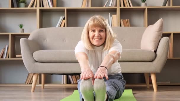 成熟した女性 自宅で瞑想を実践 心のバランスのためにヨガをする床に座って落ち着いた上級女性 呼吸空気 リラックス — ストック動画