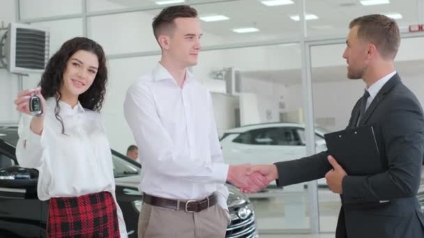 一个年轻的家庭会咨询汽车经销店经理关于在汽车经销店选择新车型的问题 赊购新车 — 图库视频影像