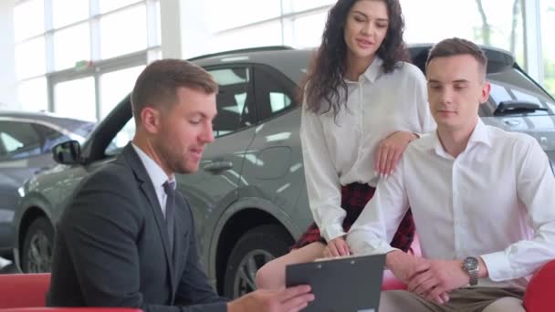 커플은 구입할 새로운 선택하는 판매자와 이야기하고 있습니다 자동차 — 비디오