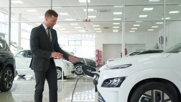 一个卖电动汽车的男性经销商谈到了汽车 现代新型电动汽车 — 图库视频影像