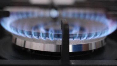 Mutfak ocağında ateş yakmak. Ocağın kızgın ateşine yakın çekim. Gaz mavi alevini yak. Ocakta bir alev yanıyor.