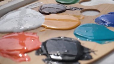 Bir sanatçı bir atölyede soyut bir yağlı boya resim üzerinde çalışır. Resim çizme konsepti. Resim oluşturma hobisi.