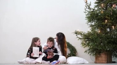 Mutlu genç aile Noel tatili boyunca Noel ağacının yanında birlikte vakit geçirir. Aile değerleri.