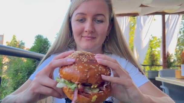 Blondynka Jedząca Podwójnego Hamburgera Restauracji Szybkiej Obsługi Portret Głodnej Kobiety — Wideo stockowe