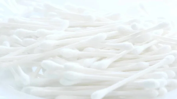 White cotton swabs, cotton swab on a clean white background. Slow motion.