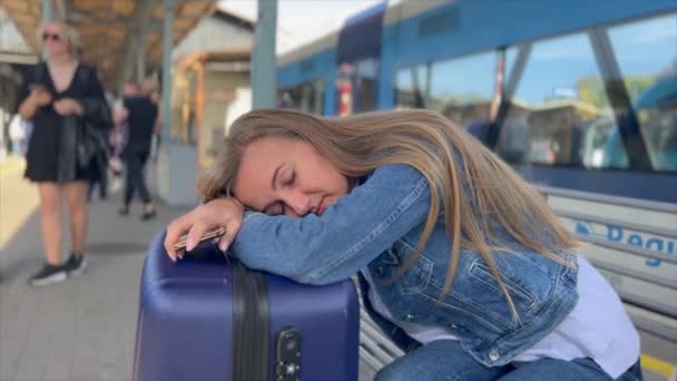 駅で寝ている女性 彼女は列車を待つのに疲れていた 列車でヨーロッパを旅する観光客 — ストック動画