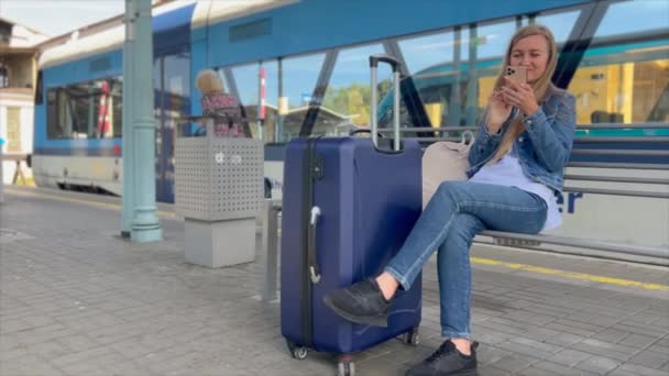 Uma Mulher Usa Smartphone Enquanto Espera Por Trem Uma Estação — Vídeo de Stock