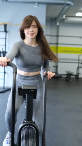 适合有魅力的黑发女子在健身房做空中自行车运动 一位年轻的女运动员正在做有氧运动训练 交叉健身和锻炼的概念 垂直录像 — 图库视频影像