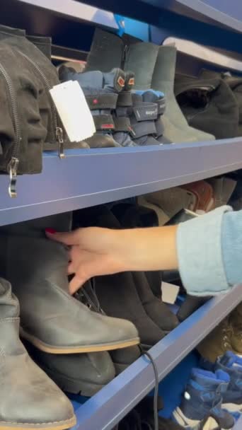 Een Vrouw Onderzoekt Tweedehands Schoenen Een Tweedehands Winkel Verkoop Van — Stockvideo