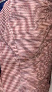 Mağazada kıyafet satışına bakan bir kadının yakın çekimi. Promosyon giysileri satışı. Dikey video.