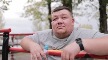 Spor sahasında depresif şişman bir adamın portresi. Obezite sorunu. Fazla kilolu.