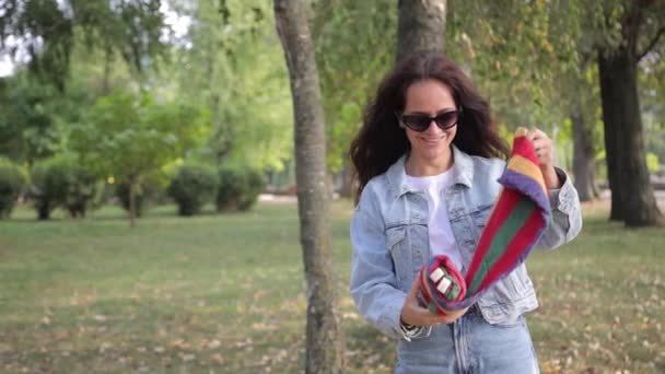 Μια Νεαρή Μελαχρινή Ξεκουράζεται Ένα Πάρκο Του Φθινοπώρου Χρησιμοποιώντας Μια — Αρχείο Βίντεο