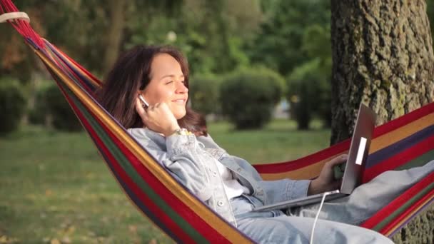 Belle Femme Écoutant Musique Dans Hamac Parc Aide Ordinateur Portable — Video