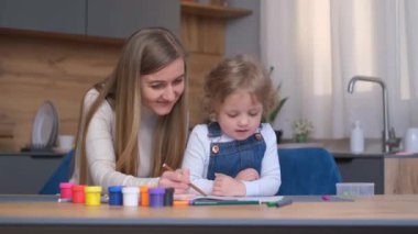 Anne ve çocuk yaratıcılıkla uğraşıyorlar. Mutlu bir aile. Anne ve kızı birlikte hareket eder. Yetişkin bir kadın bir kıza yardım eder..