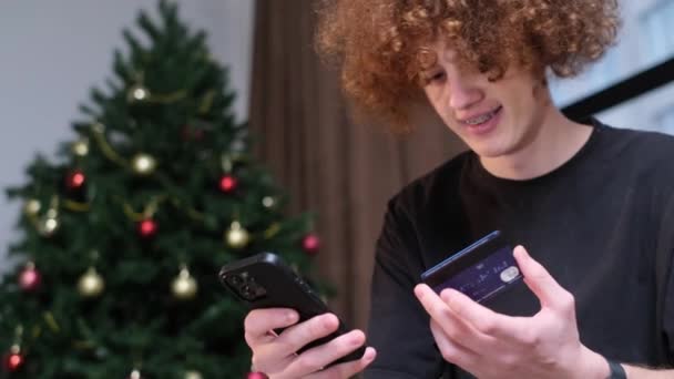 Ung Kille Gör Inköp Smartphone Gåvor Till Julhelgen Julgran Ramen — Stockvideo
