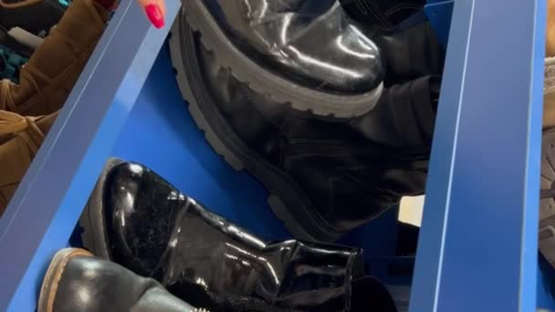 Купка Вживаного Взуття Полиці Ринку Жінка Оглядає Підбирає Взуття Друга — стокове відео