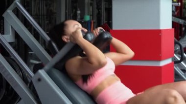 Spor salonunda ağırlık çalışması. Bir kadın antrenman yapıyor. Halter çöker..