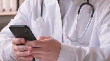 Bir doktor hasta hastalarla iletişim kurmak için akıllı telefon kullanır. Çevrimiçi tedavi.