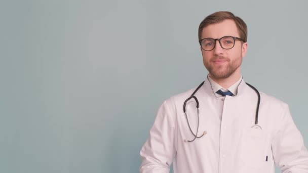 スタジオで手のジェスチャーを示す白い医学の制服の医者 — ストック動画