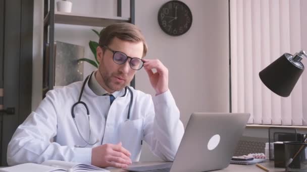 Młody Lekarz Telemedycyny Lekarz Pracujący Nad Komputerem Bólem Głowy Męskiego — Wideo stockowe
