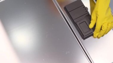 Bulaşık kapsülünü bulaşık makinesine yüklüyorum. Bulaşıkları yıkamak için bir kadın bulaşık makinesini açıyor..