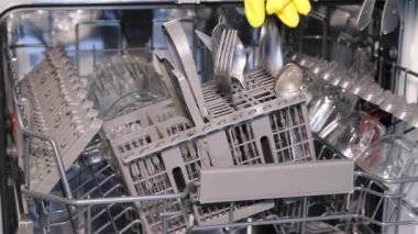 Kirli bulaşıkları, modern ev mutfağındaki paslanmaz çelik bulaşık makinesine beyaz tabakları yerleştiren kadınların yakın plan fotoğrafları. Yıkama