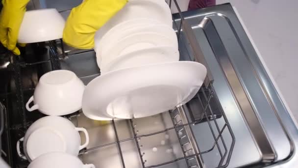 在现代化的家庭厨房里 女性手拿着脏盘子的特写镜头 把白色盘子放进开放式的自动内置式不锈钢洗碗机 — 图库视频影像