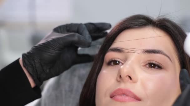 这个女美容师在螺纹眉毛纹身的帮助下做了记号 用钢丝绳在眉毛周围做导引线 以获得精确的微珠测量结果 — 图库视频影像