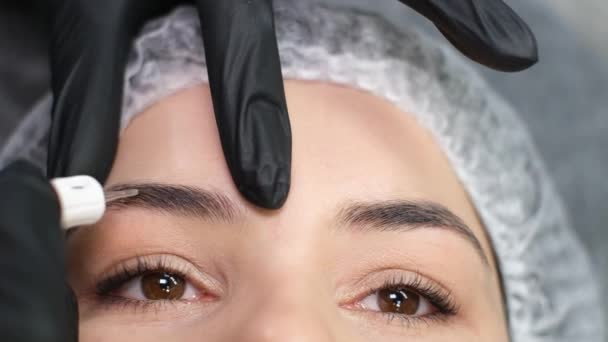 Cosmetician Luvas Fazendo Maquiagem Sobrancelha Permanente Para Uma Mulher Salão — Vídeo de Stock