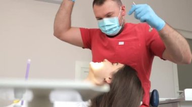 Erkek dişçi kadın hastanın dişlerini muayene ediyor. Sağlıklı dişler ve ilaçlar, stomatoloji konsepti.