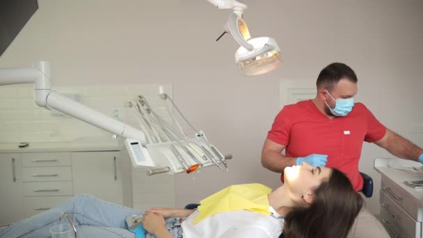 Dentista Com Uma Máscara Protetora Luvas Trata Dentes Uma Jovem — Vídeo de Stock