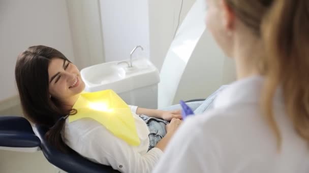 Μια Νεαρή Ενήλικη Ασθενής Κάθεται Μια Οδοντιατρική Καρέκλα Και Μιλάει — Αρχείο Βίντεο