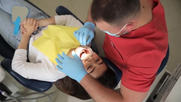 歯科医は現代歯科クリニックの患者にゴムエクステンダーを使用しています コファダム — ストック動画