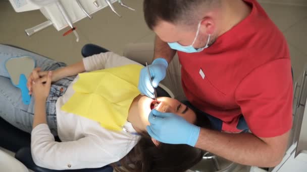 Κάτοψη Ενός Νεαρού Ελκυστικού Οδοντίατρου Που Κουράρει Δόντια Μιας Νεαρής — Αρχείο Βίντεο