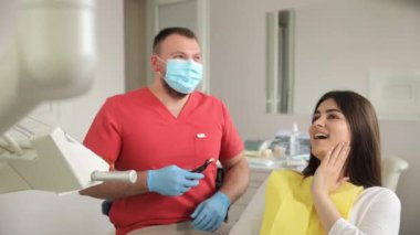 Bir dişçi modern bir klinikte dişleri tedavi eder. Dişlerin ağrıyor. ağrısız diş tedavisi.