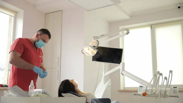 The dentist, with the help of an assistant, conducts a professional examination of the patients oral cavity. Modern clinic