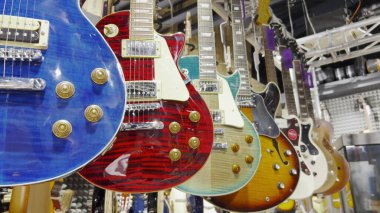Birçok elektronik bas gitar dükkandaki duvarda asılı..