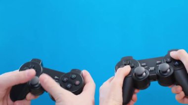 Mavi arkaplanda iki oyun denetleyici izole edildi.