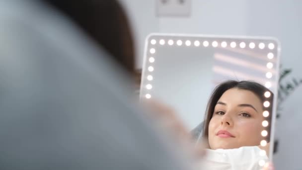 Una Bella Donna Guarda Allo Specchio Dopo Procedure Cosmetiche Cura — Video Stock