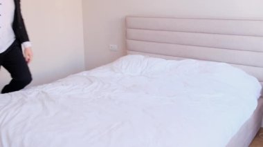 Resmi olarak yorgun işadamı iş gezisi sırasında otel odasında çift kişilik yatakta dinleniyor. İşte çok çalıştım..