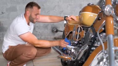  Bir adam retro motorun motorunu siliyor. Araba ve motosiklet koleksiyoncusu. Bisiklet aşkı. 